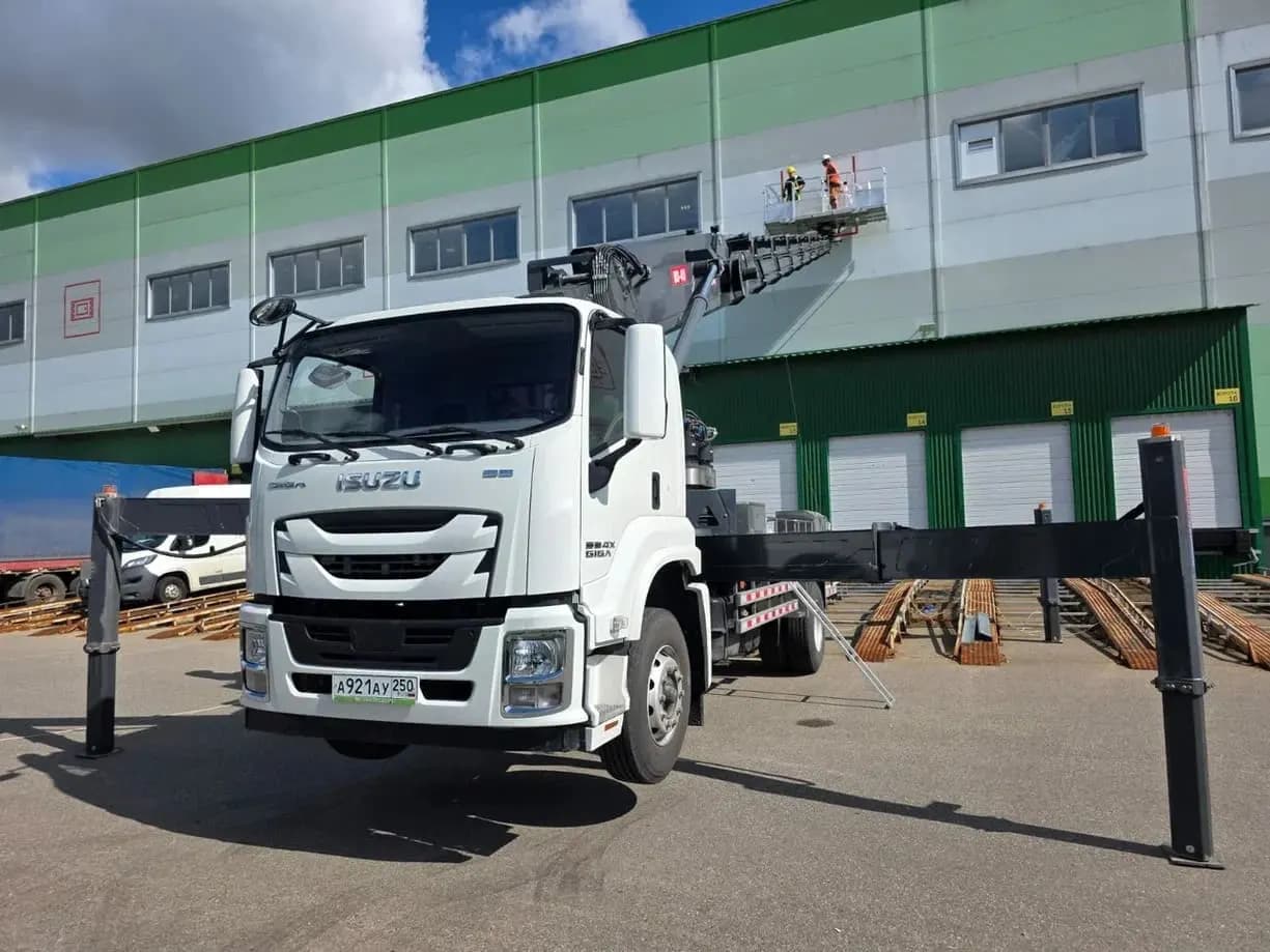 Автовышка Isuzu на работах по фасаду складского комплекса
