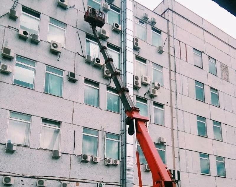 Автовышка у фасада с блоками кондиционеров